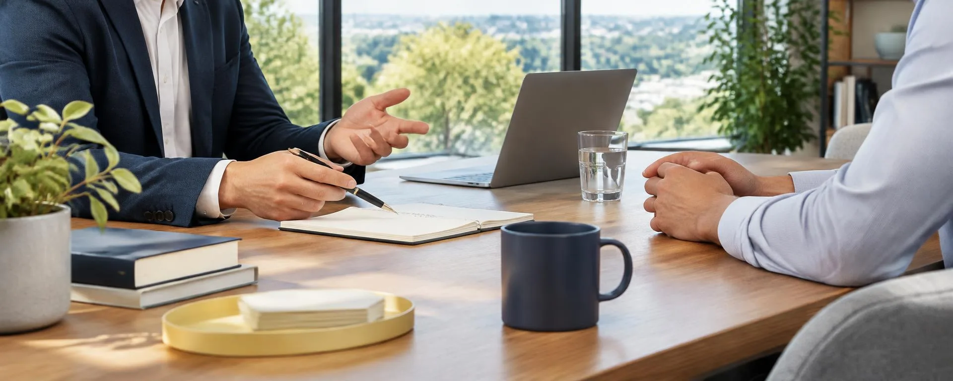 Anonymous professionals discussing business strategy across a desk in a bright office